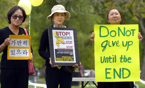 Rick Egan  |  The Salt Lake Tribune

L-R Hyesoon Heiner, Jungsu Oh, and Youngran Kuk hold a signs in honor of the victims of the South Korea ferry disaster, during a rally at Liberty Park, Sunday, May 18, 2014.  The rally was held to remember, honor and pray for victims and families of the South Korea ferry disaster that killed more than 300 people, mostly high school students, on April 26. It was organized by Korean ex-patriots living in Utah as part of a 50-state rally organized by Missy USA, a social website catering to Korean and Korean American women in the U.S.