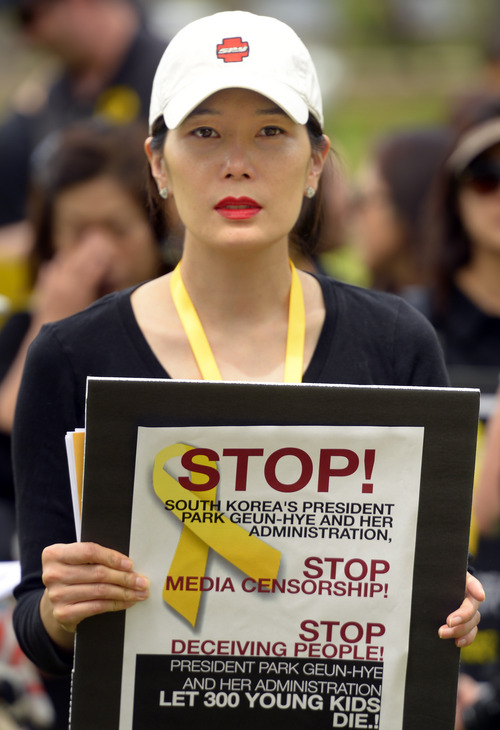Rick Egan  |  The Salt Lake Tribune

Hyoeum Yi holds a sign as she marches  in honor of the victims of the South Korea ferry disaster, during a rally at Liberty Park, Sunday, May 18, 2014.  The rally was held to remember, honor and pray for victims and families of the South Korea ferry disaster that killed more than 300 people, mostly high school students, on April 26. It was organized by Korean ex-patriots living in Utah as part of a 50-state rally organized by Missy USA, a social website catering to Korean and Korean American women in the U.S.