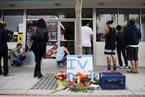 Some flowers are left in front of IV Deli Mart, where part of Friday night's mass shooting took place by a drive-by shooter, on Saturday, May 24, 2014, in Isla Vista, Calif. Alan Shifman, a lawyer who represents Hollywood director Peter Rodger, says the family believes Rodger's son, Elliot Rodger, was the lone gunman who went on the shooting rampage near the University of California at Santa Barbara. (AP Photo/Jae C. Hong)