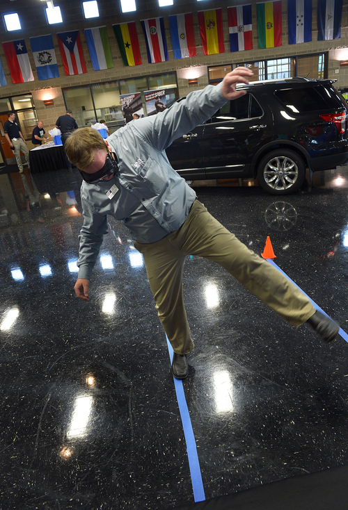 Scott Sommerdorf   |  The Salt Lake Tribune
Ford vendor Ryan Wright tries out goggles that are designed to mimic the impairment of various levels of intoxication, as he tries to walk a line at the Statewide DUI Conference.