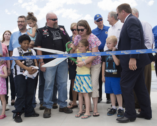 Steve Griffin  |  The Salt Lake Tribune


Kathy Newbold and her 7-year-old daughter, Taylor, cut the ribbon during the grand opening of the Sierra Newbold Playground in West Jordan, Utah Friday, May 30, 2014. Kathy was Sierra's mother and Taylor was her sister. The playground is named after the 6-year-old girl who was abducted from her home on June 26, 2012, and killed. The new playground is part of the Ron Wood Park, which is named after a West Jordan police officer who was shot and killed Nov. 18, 2002, by a 17-year-old suspect wanted in connection with a string of burglaries. When all phases are complete, the park will total about 64 acres.