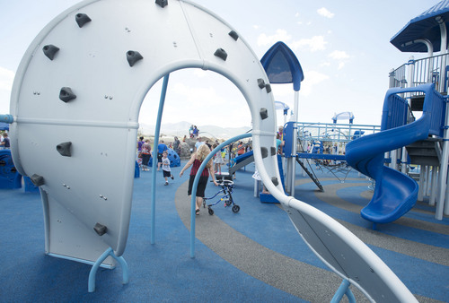 Steve Griffin  |  The Salt Lake Tribune


People play in the playground during the grand opening of the Sierra Newbold Playground in West Jordan, Utah Friday, May 30, 2014. The playground is named after the 6-year-old girl who was abducted from her home on June 26, 2012, and killed. The new playground is part of the Ron Wood Park,  which is named after a West Jordan police officer who was shot and killed Nov. 18, 2002, by a 17-year-old suspect wanted in connection with a string of burglaries. When all phases are complete, the park will total about 64 acres.
