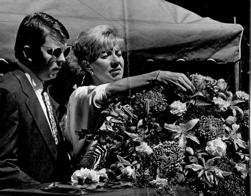 Tribune File Photo
Karen Watkins pulls a flower from her son's coffin following a funeral ceremony. Todd Watkins, Brian's older brother, is on left. Sept. 8, 1990.