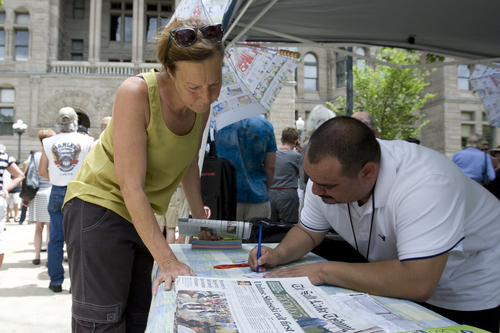 Melissa Majchrzak  |  Special to the Tribune
Sharon Woodward signs up for a subscription to the Salt Lake Tribune at the "Save the Tribune" rally, held at the City and County building in Salt Lake City on May 31, 2014.