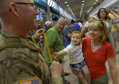 Scott Sommerdorf   |  The Salt Lake Tribune
22 -month-old Hudson Hawkins beams up at his grandfather, Chief William Erickson, as he returned from a 12-month deployment to Afghanistan. Members of the Guard's 65th Field Artillery Brigade were greeted by their loved ones at Salt Lake City International Airport, Saturday, May 31, 2014.