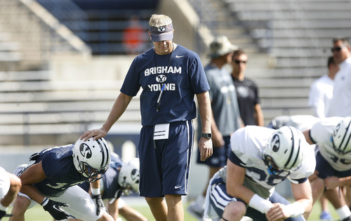 Scott Sommerdorf   |  The Salt Lake Tribune
BYU head coach Bronco Mendenhall pats a player on the head as he walks among them as they stretch prior to scrimmage at LaVell Edwards Stadium, Saturday, August 10, 2013.