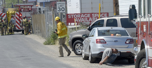 Al Hartmann  |  The Salt Lake Tribune
A man is held in handcuffs as Murray Fire and Unified Fire departments respond to a suspicious fire in a storage unit building at 4000 South and West Temple Wednesday June 11, 2014.  About six storage units were burned.