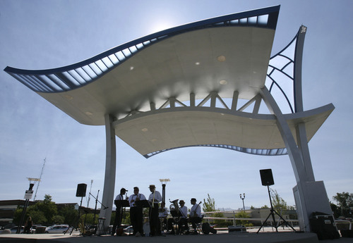 Steve Griffin  |  Tribune file photo
A band plays at West Valley City's new Fairbourne Station Promenade, a four-acre park located behind the West Valley City Hall in West Valley City, during its 2012 grand opening. The city has worked out a deal with UTA for a parking structure at the TRAX station.