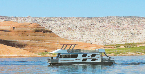 Al Hartmann  |  Tribune file photo. A houseboat heads out Bullfrog Bay into the main channel of Lake Powell in this 2009 photo.