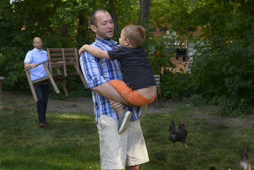 Scott Sommerdorf   |  The Salt Lake Tribune
Matt Barraza holds his son, Jesse Milner-Barraza, as Jesse's other Dad, Tony Milner brings a chair as they play in the back yard after school, Friday, June 13, 2014.