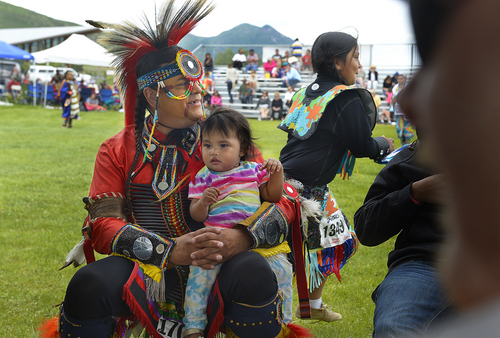 Scott Sommerdorf   |  The Salt Lake Tribune
Jesse Eagle Speaker from Pablo, Montana, holds his year-old daughter Suzy as dancers perform at the Heber Valley Pow-Wow at Soldier Hollow, Sunday, June 15, 2014.