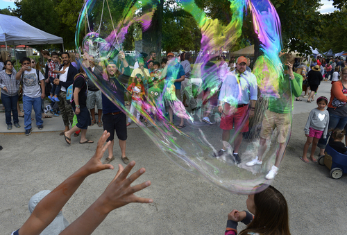 Scott Sommerdorf   |  The Salt Lake Tribune
Kids reach for huge soap bubbles created by Griffen Merrill of "Monster Bubbles" on Saturday at the opening day of the 2014 Downtown Farmers Market at Pioneer Park.