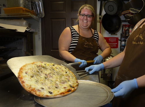 Scott Sommerdorf   |  The Salt Lake Tribune
Graziela Drogueti pulls out a finished Portuguesa pizza from the oven at the Sweet Spot Bakery and Cafe, Friday, June 13, 2014.