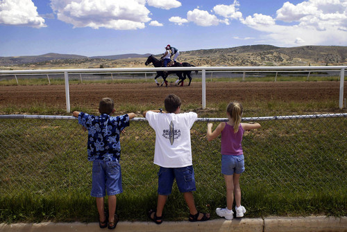 Joshua Brown  |  Tribune file photo
Children watch as Chad Giles rides by  on his way to the third race of the day at Wyoming Downs on Sunday. 8/10/03