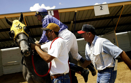 Joshua Brown  |  Tribune file photo
Lee Giles helps Chad Giles onto his horse for the fourth race of the day on the horse Willie Digs Dirt.
 8/10/03
