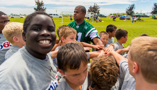 Trent Nelson  |  The Salt Lake Tribune
Andre Dyson huddles with youth as retired and current NFL players stage a training session as part of the NFL Play 60 program, in Layton, Friday June 20, 2014.
