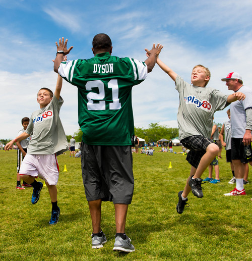 Trent Nelson  |  The Salt Lake Tribune
Andre Dyson high-fives kids as retired and current NFL players stage a training session as part of the NFL Play 60 program, in Layton, Friday June 20, 2014.