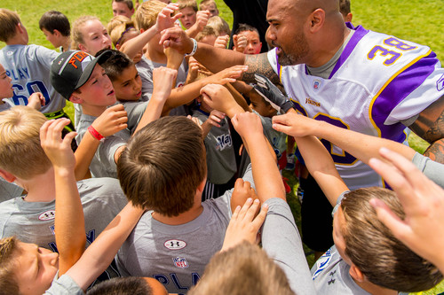 Trent Nelson  |  The Salt Lake Tribune
Naufahu Tahi huddles with kids as retired and current NFL players stage a training session as part of the NFL Play 60 program, in Layton, Friday June 20, 2014.