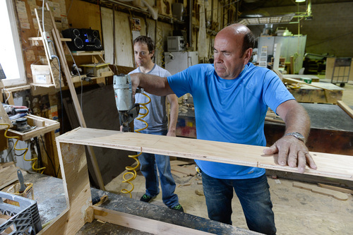 Francisco Kjolseth  |  The Salt Lake Tribune
Kerry Hamblin, owner of Hamblin Custom Furniture Frames, works in his shop next to UTA headquarters. At left is his son Ryan. The Utah Transit Authority technically does not have the power of eminent domain to condemn property. But it had UDOT using its eminent domain on UTA's behalf to condemn the furniture company to make way for a new garage by UTA headquarters. The company says it would cost $2 million to relocate, and UTA is offering only $260,000 and suing.