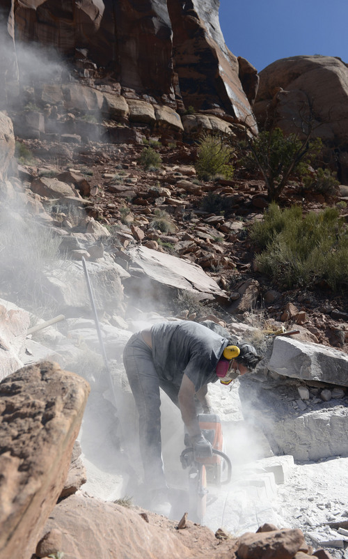 Al Hartmann  |  The Salt Lake Tribune 
Natural History Museum of Utah prep lab manager Tylor Birthisel cuts through sandstone with a rock saw to remove rock to get down to an aligator-like fossil embedded in the sandstone cliffs near Canyonlands National Park.