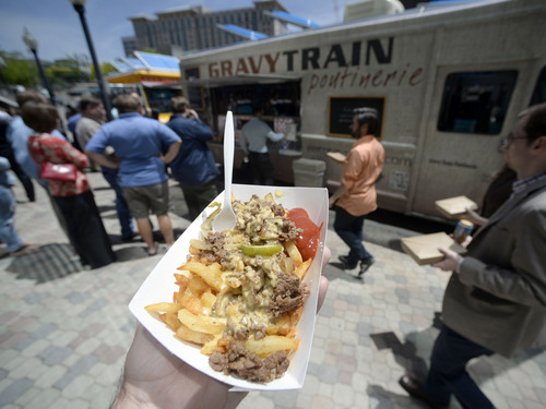 Al Hartmann  |  The Salt Lake Tribune
"The Philly," hand-cut fries, grilled peppers, caramelized onion, aged cheddar, gravy and steak, comes off the Gravy Train Poutinerie at the weekly food truck rally at the Gallivan Center Thursday June 19.