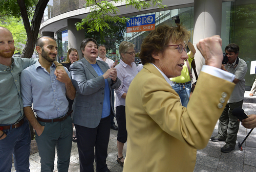 Scott Sommerdorf   |  The Salt Lake Tribune
Peggy Tomsic, lawyer for the three same sex couples who were plaintiffs in the 2013 lawsuit versus Utah, raises her fist as she celebrates the ruling outside her offices in Salt Lake City, Wednesday, June 25, 2014. Tomsic said: (the ruling) "affirms the fundamental principles of equality and fairness and the common humanity of gay and lesbian people." In the background are, left to right, Derek Kitchen, Moudi Sbeity, Kate Call, and Laurie Wood.