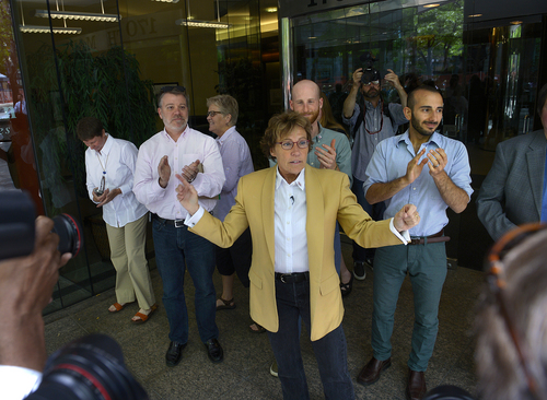 Scott Sommerdorf   |  The Salt Lake Tribune
Attorney Peggy Tomsic, center, emerged from her offices to applause as she made her way to a press conference with staff and her clients where she commented on the ruling from the 10th Circuit outside her offices in Salt Lake City, Wednesday, June 25, 2014. Tomsic said: (the ruling) "affirms the fundamental principles of equality and fairness and the common humanity of gay and lesbian people."