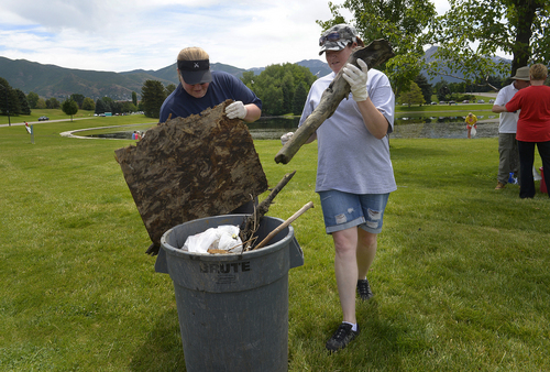 Scott Sommerdorf   |  The Salt Lake Tribune
Yno Martin, left, and Alisha Prince dump what they've cleaned from the Sugar House duck pond. United Way Salt Lake sponsors Summer of Service every summer. One of the volunteer opportunities is to help the Aviation and Sanctuary Protection group (ASAP) clean up Sugar House park. The idea is to clean up all the garbage and trash around the pond that sometimes make domestic birds (geese, ducks, etc.) sick, Saturday, June 21, 2014.