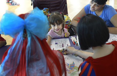 Scott Sommerdorf   |  The Salt Lake Tribune
Four year old Melanie Hernandez beams as she looks up at princesses Ariel (Marshay Norton), at left, and Snow White, (Christine Carr), right, as they help her with her coloring. Melanie's mother Arely Hernandez is at top right. Costumed characters visited children at Shriner's Hospital, Thursday, June 25, 2014. The visit is in preparation for FantasyCon's "Night of Dreams" - a special preview event only July 2 for families associated with eight local charities that serve special needs and critically ill children.