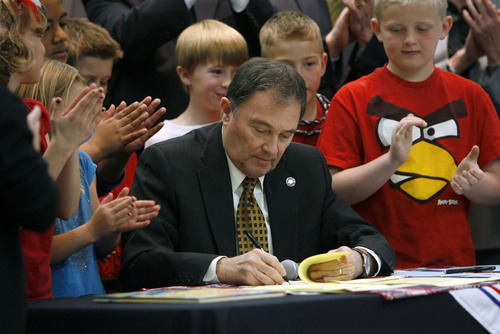 Francisco Kjolseth  |  The Salt Lake Tribune
Governor Gary R. Herbert, surrounded by state representatives and third-graders from Falcon Ridge Elementary in West Jordan signs three education-related bills following a flag ceremony assembly on Tuesday, March 27, 2012.