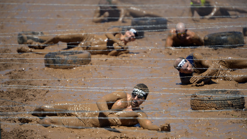 Rick Egan  |  The Salt Lake Tribune

Competitors slip, and roll down the hill,  under the final barbwire crawl, in the 2014 Salt Lake City Spartan Beast race, at Soldier Hollow, Saturday, June 28, 2014.  Spartan Beast Competitors face 29 obstacle's in the 12 mile run.