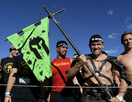 Rick Egan  |  The Salt Lake Tribune

Cory McCurdy prepares for the race with a banner in hand, in the 2014 Salt Lake City Spartan Beast race, at Soldier Hollow, Saturday, June 28, 2014.  Spartan Beast Competitors face 29 obstacle's in the 12 mile run.