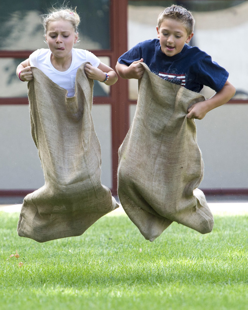 Rick Egan  |  The Salt Lake Tribune

Eight-year-old Shelby Green, and Aspen Borden, 9, compete in the gunny sack races, during the Hurricane Independence day festivities,  Friday, July 4, 2014