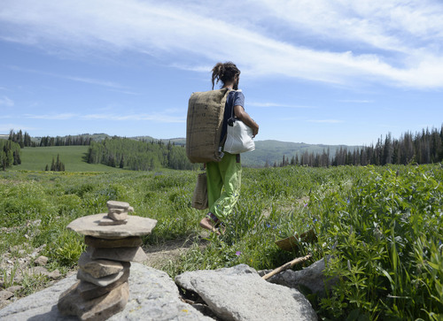 Al Hartmann  |  The Salt Lake Tribune 
Ashkan Suberi, 25, from Iran who has lived and worked with the Rainbow family in South America walks barefoot on a foot trail into the Rainbow Family Gathering in the Uinta Mountains 15 miles northeast of Heber.  He carries most of his life's belongings in a burlap coffee sack turned into a backpack.