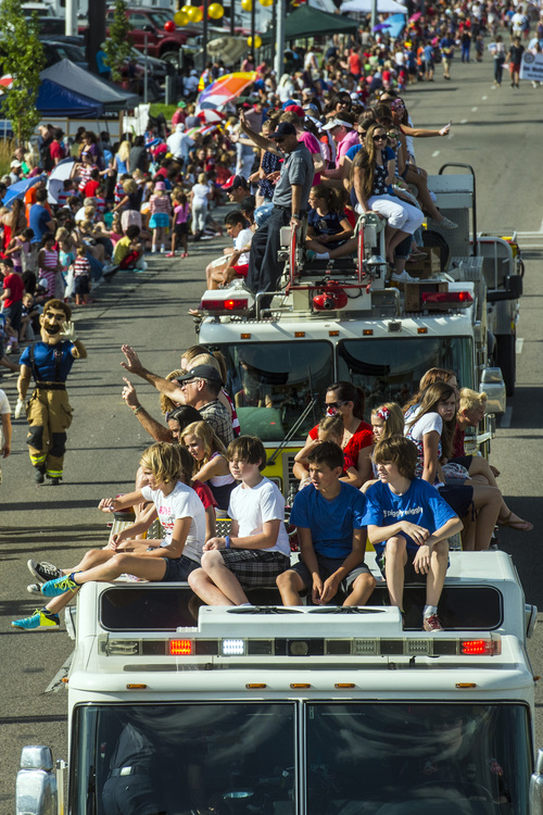 Chris Detrick  |  The Salt Lake Tribune
Kids ride on top of fire trucks in the Murray 2014 Fun Days Parade along State Street Friday July 4, 2014.