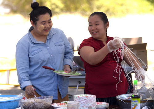 Leah Hogsten  |  The Salt Lake Tribune
l-r Mulahqie Pye, 21, and YeYe Win, 26, share a laugh while plating up free food at the 6th annual Burmese Water Festival, Saturday, July 5, 2014, a celebration of the Burmese New Year, traditionally held in April. The Burmese community gathers money from its members for free dance performances, food and fun.