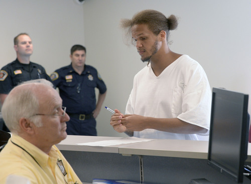 Al Hartmann  |  The Salt Lake Tribune 
Prison inmate Aaron Hukill applies at the Utah Driver License Division office set up at Utah Prison in Draper Tuesday July 8 to receive temporary state identification documents before being released.  HB 320, passed in 2013 allows eligible individuals to get a temporary state identification document while they gather necessary papers to apply for a permanent ID.
The Utah Department of Corrections and Utah Driver License Division have set up a driver license office at the Utah State Prison to provide eligible offenders with a temporary ID document on the day of their release, ensuring they leave prison with the identification they need to rejoin the community. The documents are valid for six months. The program launched July 1.