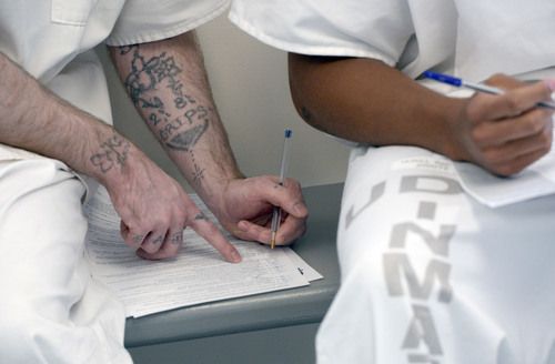 Al Hartmann  |  The Salt Lake Tribune 
Prison inmates fill out application at the Utah Prison in Draper Tuesday July 8 to receive temporary state identification documents before being released.  HB 320, passed in 2013 allows eligible individuals to get a temporary state identification document while they gather necessary papers to apply for a permanent ID.
The Utah Department of Corrections and Utah Driver License Division have set up a driver license office at the Utah State Prison to provide eligible offenders with a temporary ID document on the day of their release, ensuring they leave prison with the identification they need to rejoin the community. The documents are valid for six months. The program launched July 1.