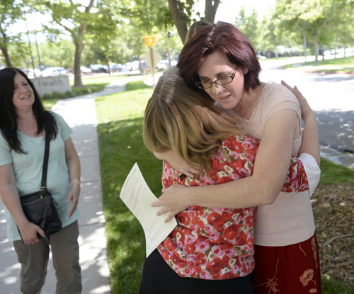 Al Hartmann  |  The Salt Lake Tribune 
Annette Maughan, right, holds her hemp extract permit, or cannabis oil permit and gets a hug from Janice Houston, state registrar for the Utah Dept. of Health Tuesday July 8.  Maughan applied and got one of the first permits issued. Her son Glenn, 11, has epilepsy and would benefit from the oil. 
The new state law allows to import the supplement from a company in Colorado called Realm of Caring. To get the permit the patient needs to prove they have intractable epilepsy ó or epilepsy that is resistant to at least three or more treatments.
