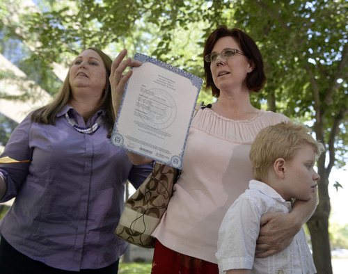Al Hartmann  |  The Salt Lake Tribune 
Annette Maughan, holds her hemp extract permit, or cannabis oil permit outside the Utah Dept. of Health Tuesday July 8.  Her son Glenn, 11, has epilepsy and would benefit from the oil. Friend Jennifer May, left.  Maughan and May are co-founders of Hope for Children with Epilepsy. 
The new state law allows to import the supplement from a company in Colorado called Realm of Caring. To get the permit the patient needs to prove they have intractable epilepsy -- or epilepsy that is resistant to at least three or more treatments.