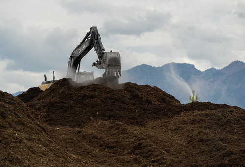 Francisco Kjolseth  |  The Salt Lake Tribune
Crews work to reduce the hill size compost pile at the South Salt Lake business that caught fire late Thursday and lit up once again on Friday drawing the ire of neighboring businesses.