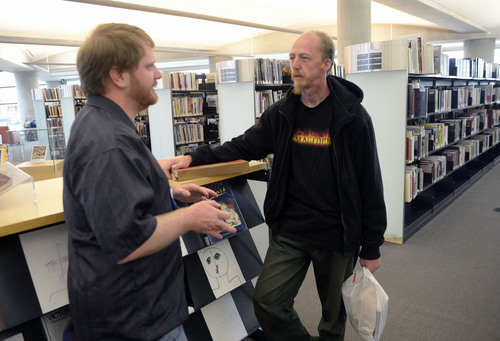 Al Hartmann  |  The Salt Lake Tribune 
Volunteers of America library engagement team member Ethan Sellers, left, talks to Thad Harman a homeless man at the Salt Lake City Library.  They discuss how he is doing and how the Volunteers of America can help him find services.