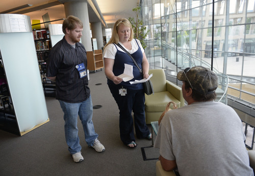 Al Hartmann  |  The Salt Lake Tribune 
The Volunteers of America library engagement team's Jen Page and Ethan Sellers introduce themselves to a homeless person in the Salt Lake City Library. They told him how Volunteers of America can help him and direct him to services.  He was looking for a job and they had suggestions on how to help.