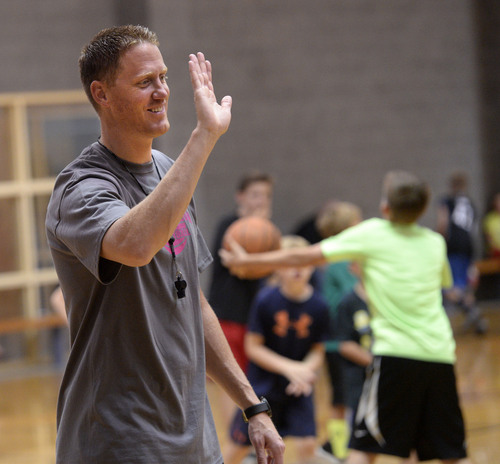 Al Hartmann  |  The Salt Lake Tribune 
Britton Johnsen, a former Ute and NBA player, helps kids with their dribbling and shooting skills at his annual basketball camp at Murray Recreation Center Monday July 14, 2014.