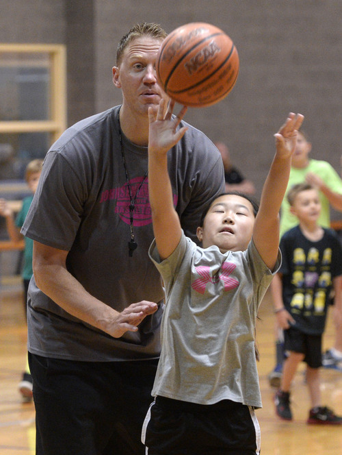Al Hartmann  |  The Salt Lake Tribune 
Britton Johnsen, a former Ute and NBA player, helps kids with their dribbling and shooting skills at his annual basketball camp at Murray Recreation Center Monday July 14, 2014.