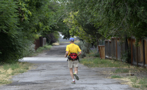 Al Hartmann  |  The Salt Lake Tribune 
A runner uses the all-but-forgotten Jordan/Salt Lake City Canal at about 1200 East and 1500 South.  It appears to just be a potholed alleyway between blocks but is actually a covered canal with a 66- foot right of way that runs the length of the Salt Lake Valley at about 1100 to 1200 East. Salt Lake City has allocated more than $1 million to build a bike and pedestrian trail on top of the canal from 2700 South to 800 South. It would be called the McClelland Trail.