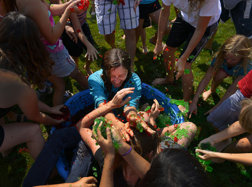 Leah Hogsten  |  The Salt Lake Tribune
Emilie Lybbert (center) of American Fork simply sat down in the middle of the jello pool to smear her best friend Helen Kepo'o with jello. Hundreds of Utahns threw food at each other Saturday. The inaugural Jiggle Fest at Thanksgiving Point Gardens, featured hourly jello fights and squeals of laughter July 19, 2014.