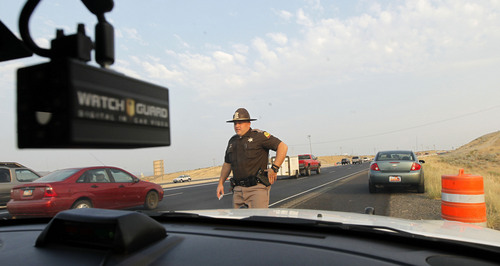 Al Hartmann  |  Tribune file photo

Utah Highway Patrolman Emery Calkins walks back to his car after pulling over a driver on I-15 in Utah County in this file photo from August 2012.