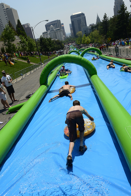 Scott Sommerdorf   |  The Salt Lake Tribune
Slide The City hosted a 1,000 foot slip-n-slide in downtown Salt Lake City, Saturday, July 19, 2014.
