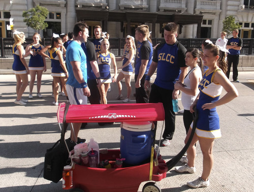 Sean P. Means  |  The Salt Lake Tribune
Lindsey Thurber (right), a cheerleader for Salt Lake Community College, takes care of the squad's water wagon in front of the Joseph Smith Memorial Building, before the 2014 Days of '47 Parade in Salt Lake City, Thursday, July 24.